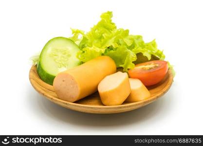Sausages, cucumber, tomato and lettuce in wooden plate on white background