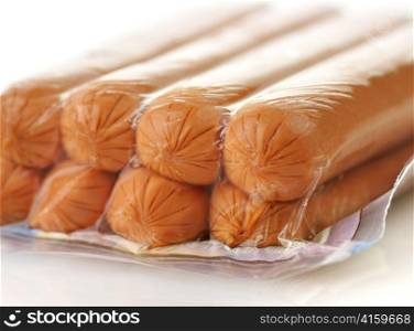 sausages in a plastic package on a white background, closeup
