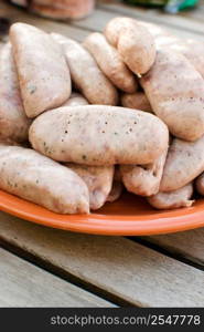 sausages in an orange plate over wooden table