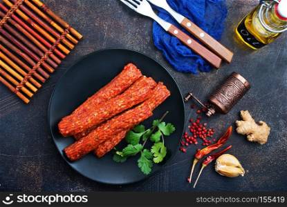 sausages on black plate, smoked sausages, sausages with spice