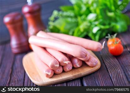 sausages on wooden board and on a table