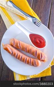 sausages with tomato sauce on white plate