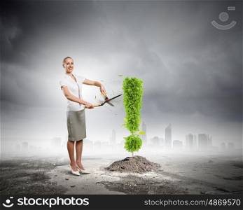 Save home. Young businesswoman cutting plant shaped like exclamation sign. Ecology concept