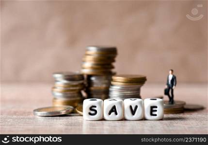 Save money concept, businessmen stand on money coin and save block word Save money for investment