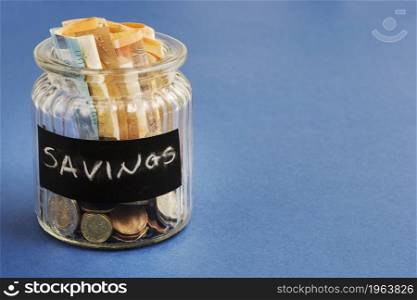 saving bottle with euro notes coins blue background. High resolution photo. saving bottle with euro notes coins blue background. High quality photo