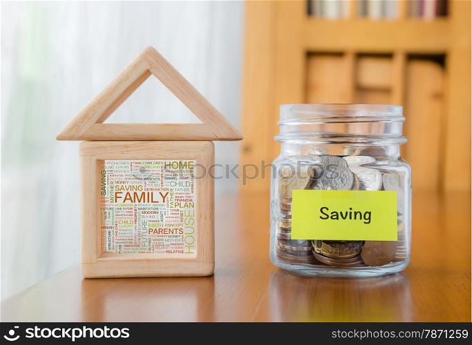 Saving label on money jar and wooden home blocks with house and family word cloud