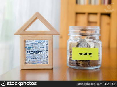 Saving label on money jar and wooden home blocks with investment property word cloud