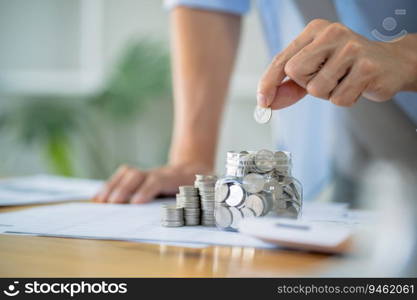Saving money. Businessman Accountant verify growing business and saving money stacking coins with calculator. Accountancy Concept
