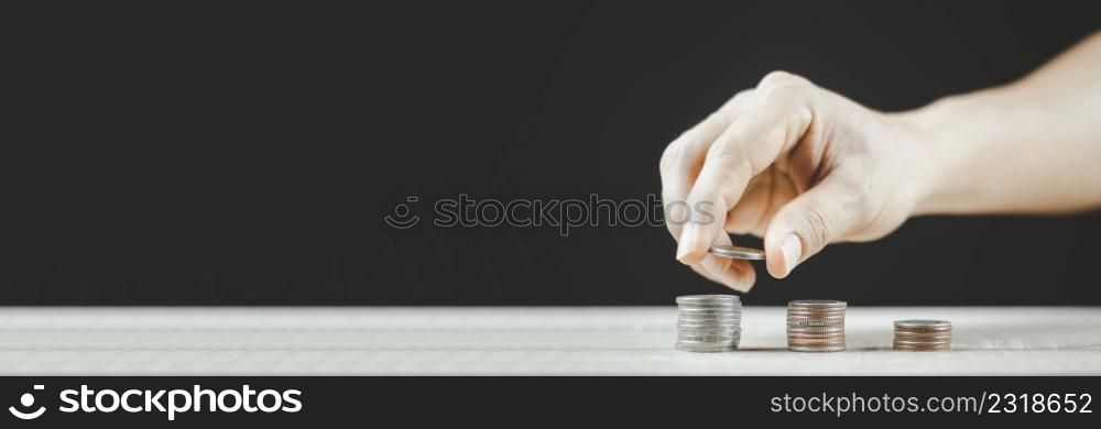 Saving money concept. Male hand putting money coin stack for the future growing business, education and retirement. He felt that saving money made his life safe.