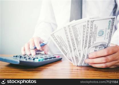 Saving money concept Man hand Holding Dollar bills and coin Write Finance