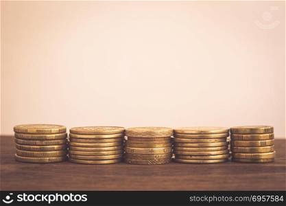 Saving money gold coins stacks, copy space. . Stack of gold coins, worldwide currency on wooden table Blank background or copy space, vintage minimal style. Money concepts for saving, fund invesment, foreign exchange, business budget planning.