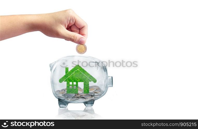 Saving money to buy a house or home savings concept with grass growing in shape of house inside transparent piggy bank