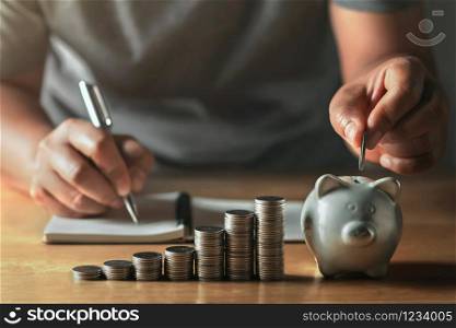 saving money with hand putting coins in piggy bank concept financial