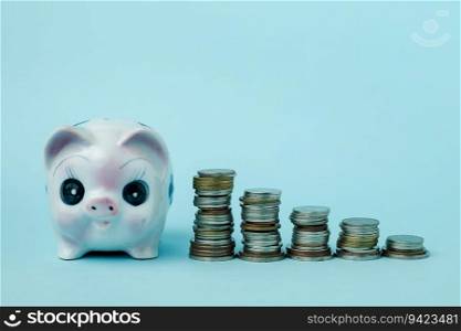 Saving piggy bank with step of money coins on blue background for investment, business, finance and saving money concept