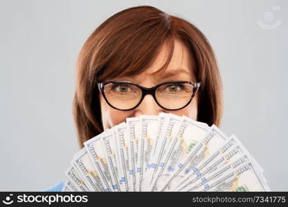savings, finances and people concept - close up of senior woman holding hundreds of dollar money banknotes. senior woman with hundred dollar money banknotes