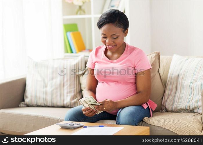 savings, finances and people concept - happy pregnant african american woman with papers and calculator counting money at home. happy pregnant woman counting money at home
