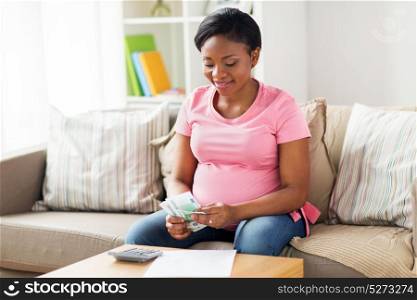 savings, finances and people concept - happy pregnant african american woman with papers and calculator counting money at home. happy pregnant woman counting money at home
