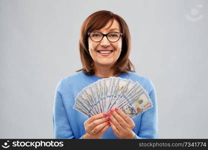 savings, finances and people concept - smiling senior woman holding hundreds of dollar money banknotes. senior woman with hundred dollar money banknotes