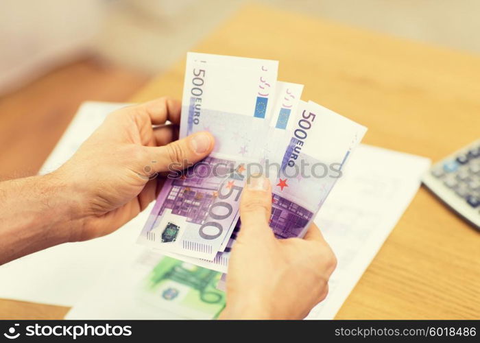 savings, finances, economy and home concept - close up of man hands counting money at home