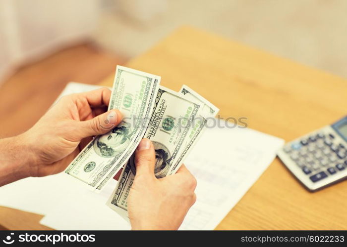 savings, finances, economy and home concept - close up of man hands counting money at home