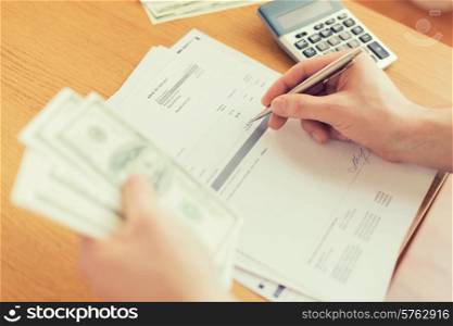 savings, finances, economy and home concept - close up of man with calculator counting money and making notes at home