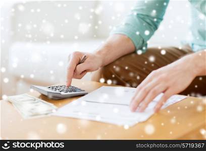 savings, finances, paperwork and people concept - close up of man with calculator counting money and making notes at home