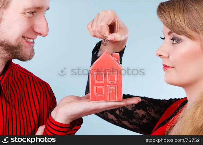 Savings for future plans. Couple with red little house piggy bank and silver coin. Money loin for family home better life.. Couple with little house and silver coin.