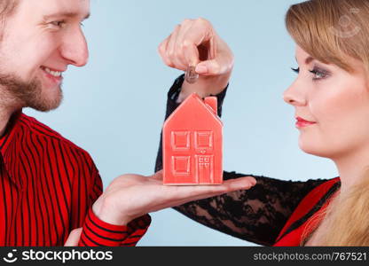 Savings for future plans. Couple with red little house piggy bank and silver coin. Money loin for family home better life.. Couple with little house and silver coin.