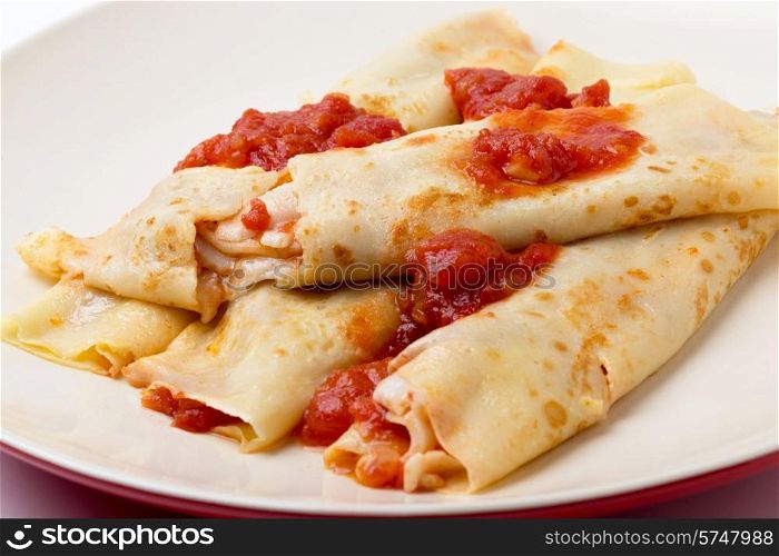 Savory pancakes filled with goats cheese and tomato salsa and garnished with more sauce.