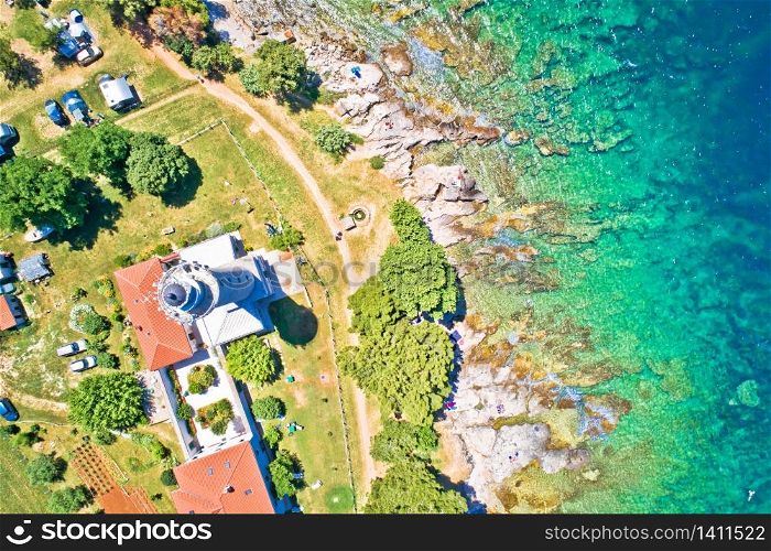 Savudrija lighthouse and turquoise crystal clear rocky beach aerial view, westernmost point of Croatia