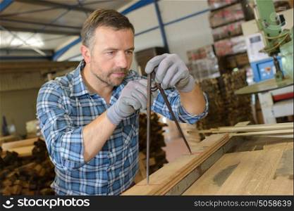sawmill employee working with wood tools and machinery