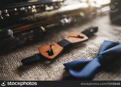 Saxophone, brass band instrument equipment on grunge sack background, closeup view. Classical sax, mouthpieces, bowtie and microphone on canvas texture. Jazz music. Saxophone, brass band instrument equipment