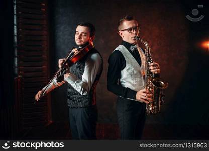 Saxophonist and violinst playing classical melody, musical duet. Jazz-man and fiddler. Saxophonist and violinst playing classical melody