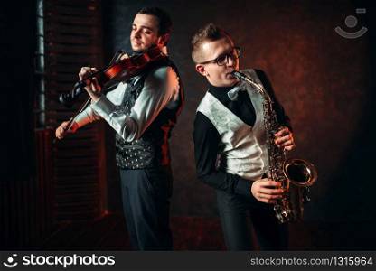 Saxophonist and violinst playing classical melody, musical duet. Jazz-man and fiddler