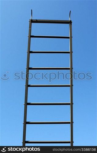 Scaling ladder against blue sky