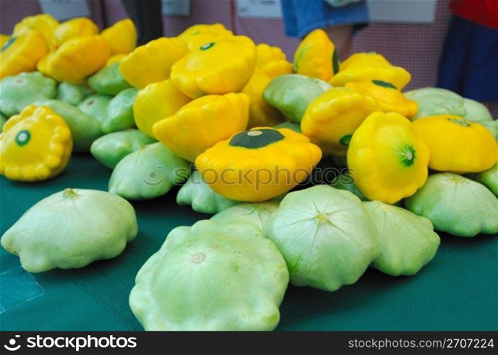 Scalloped edged green and yellow Pattypan squash on a tabletop. Pattypan or Sunburst Squash