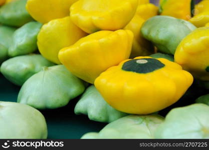 Scalloped edged green and yellow Pattypan squash on a tabletop. Pattypan Squash