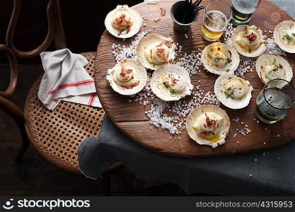 Scallops in shells on table