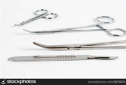 Scalpel and medical clamps on a white background. Selective focus