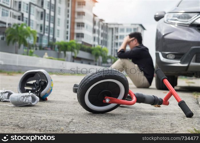 scared and stressed desperate drunken driver and bottle of beer in front of automobile crash car with child bike after traffic accident in city road