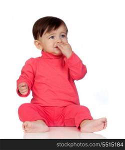 Scared baby girl with her hand in mouth sitting isolated on white background