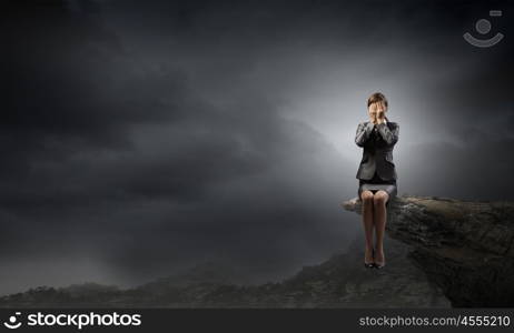 Scared businesswoman. Young businesswoman covering her eyes with hands