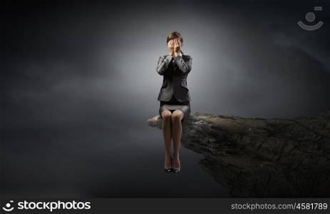 Scared businesswoman. Young businesswoman covering her eyes with hands