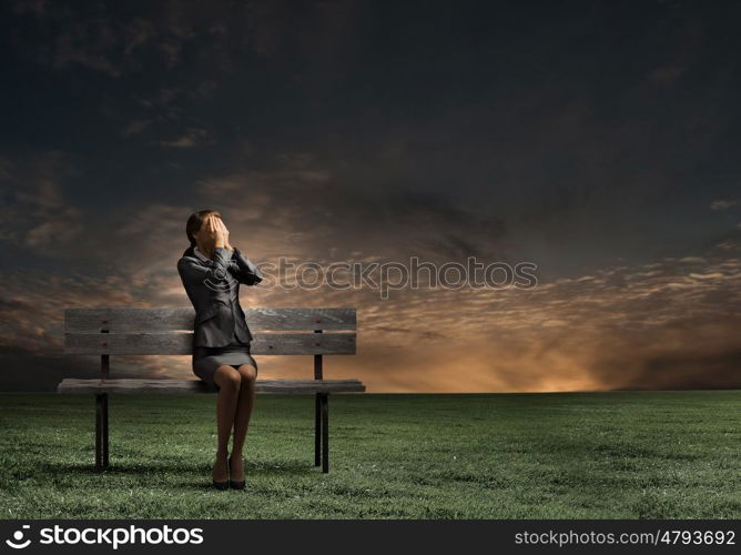 Scared businesswoman. Young businesswoman covering her eyes with hands