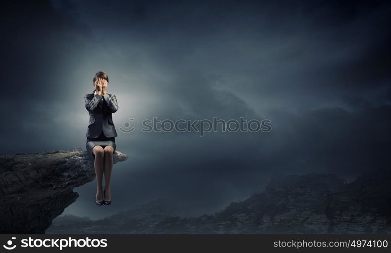 Scared businesswoman. Young businesswoman covering her eyes with hands