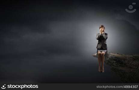 Scared businesswoman. Young businesswoman covering her eyes with hands