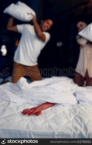 Scared family couple attack spooky bloody hand in bed with pillow. Selective focus. Couple attack bloody hand in bed with pillow