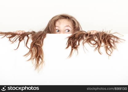 Scared little girl kid with long hair holding empty blank white banner for copyspace. Advertisement.. Little girl kid with long hair holds empty banner.