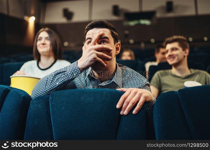 Scared man watching movie in cinema. Showtime, entertainment