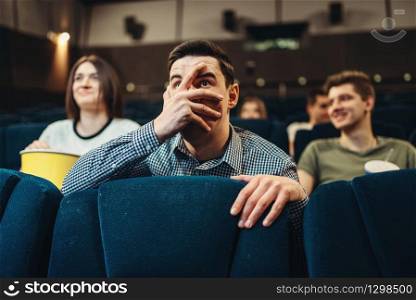 Scared man watching movie in cinema. Showtime, entertainment